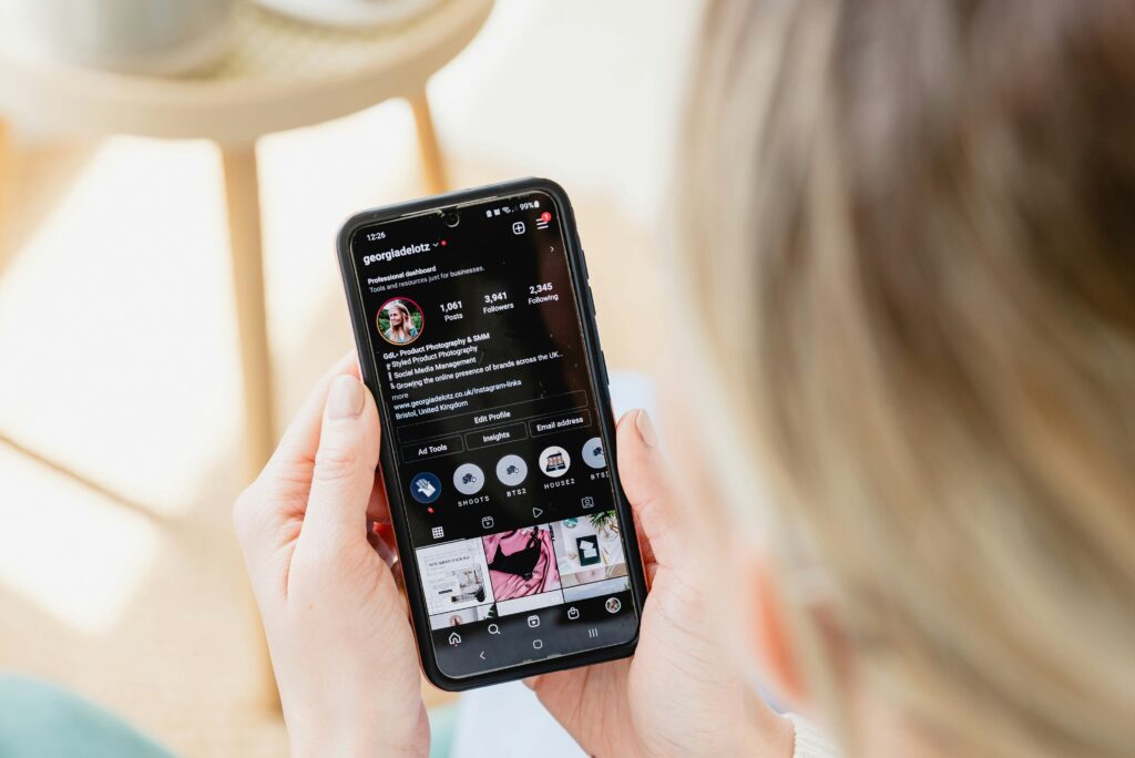 User browsing Instagram profile on smartphone, highlighting social media presence
